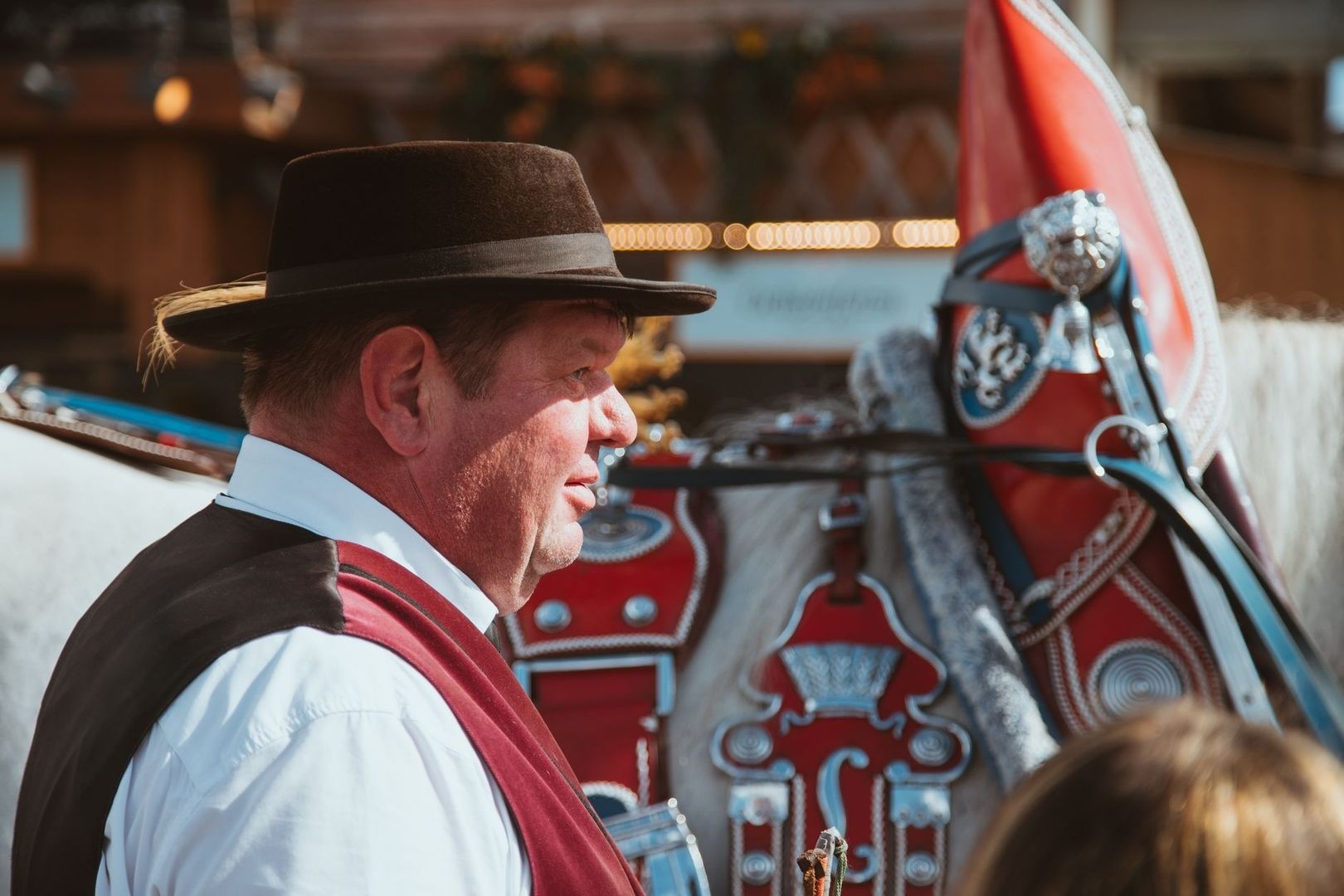 Man i traditionell festklädsel bredvid en utsmyckad häst